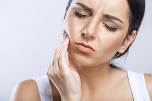 woman in pain holding jaw