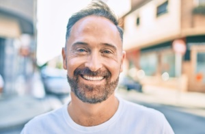 Middle age handsome man smiling happy looking to the camera at the city.